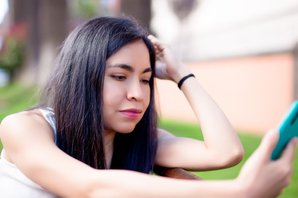 一个女人在城市里使用手机图片下载