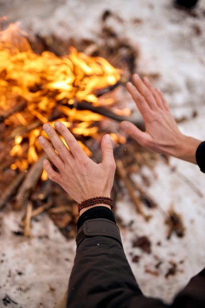 旅行者在户外的篝火旁暖手。露营细节，旅行生活照片。图片下载