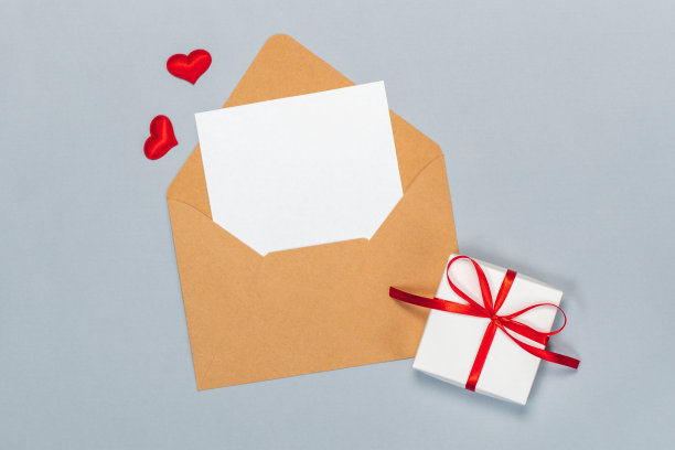 上图为情人节平铺构图，用牛皮纸信封和空白白色卡片写上祝福，孤立在灰色背景上图片下载