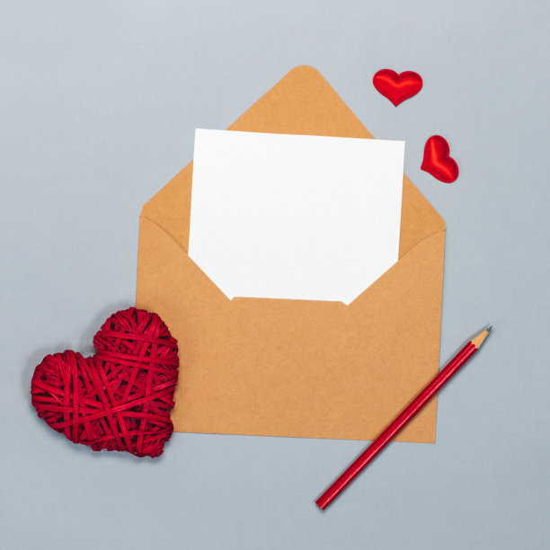 上图为情人节平铺构图，用牛皮纸信封和空白白色卡片写上祝福，孤立在灰色背景上图片下载