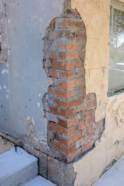 部分损坏的墙，下面露出了砖墙。图片下载