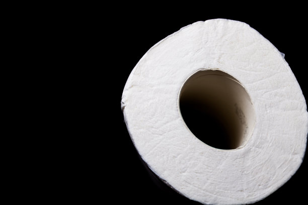黑色背景上的一卷卫生纸图片下载