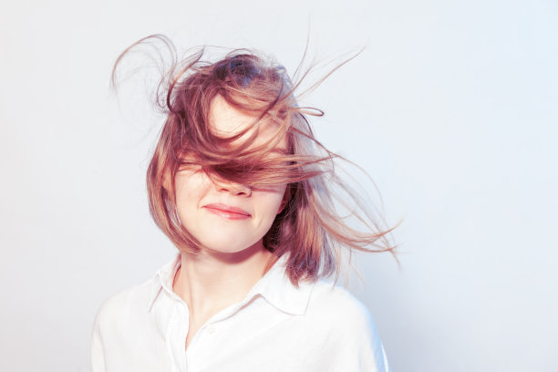 快乐的亚洲22岁女子在白色背景的白色衬衫的工作室肖像图片下载