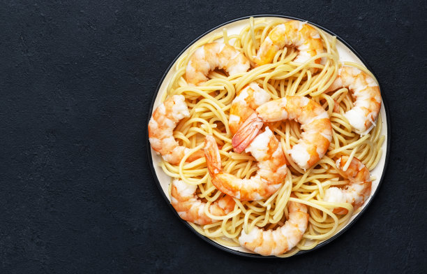意大利面配虾。黑色表背景。俯视图，复制空间图片下载