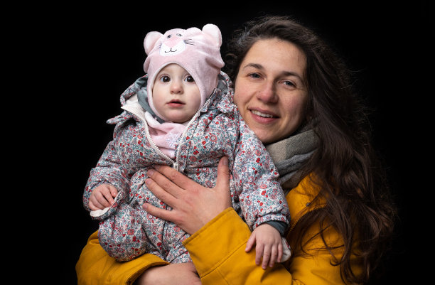 肖像的母亲与她的婴儿在黑色背景。图片下载