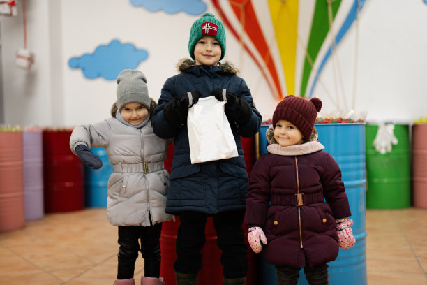 快乐的小孩子在糖果店里挑选糖果，果酱糖果，把它们放进纸袋里。图片下载