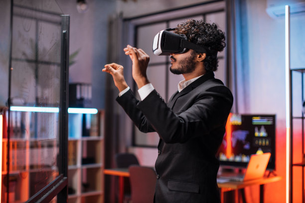 年轻的男性员工戴着VR头戴式耳机在办公室开会。图片下载