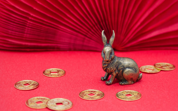 红色背景上的青铜兔兔和金币——2023年中国新年的象征，复制空间图片下载