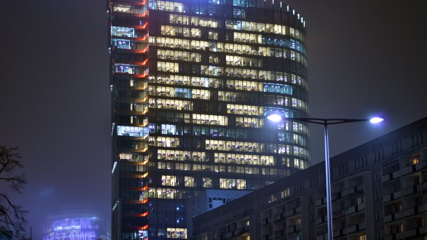 城市中现代化的办公大楼在夜晚。公司建筑的照明办公室视图。图片下载