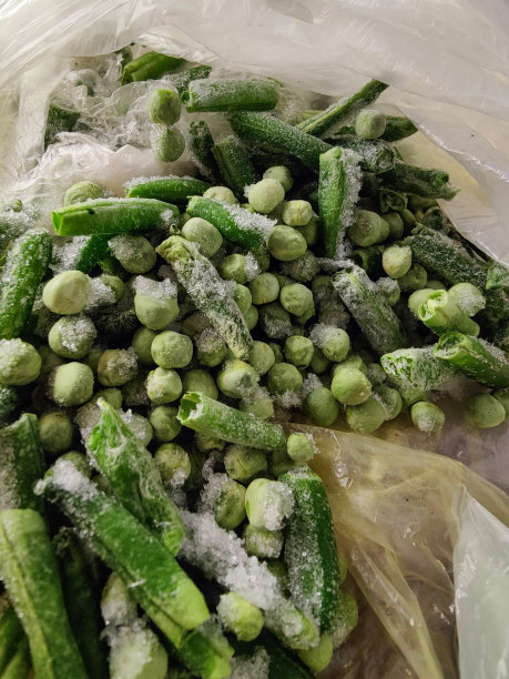 白色塑料袋里的冷冻芦笋和绿豌豆图片下载