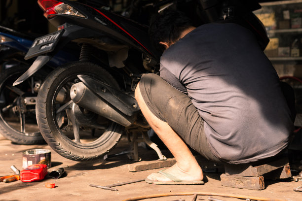 男机械师在车间修理摩托车图片下载