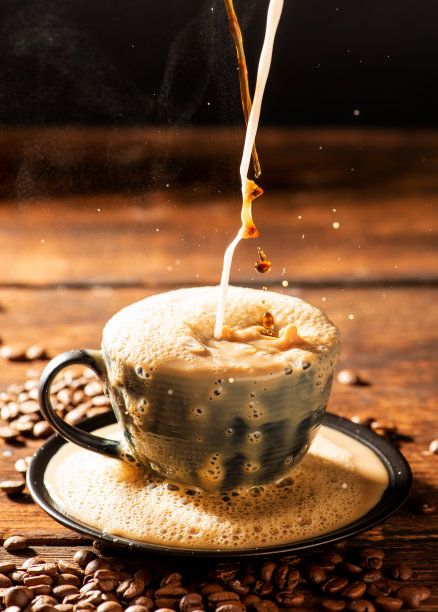 咖啡和牛奶，倒拿铁到一个黑色的杯子，深色食物风格的照片，选择性聚焦。图片下载