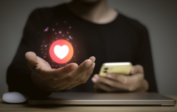 代表爱、温暖的图标，发送给爱人或家人，笔记本电脑上的社交媒体互动，信息，电子邮件，评论，商人在手机上的屏幕设备上工作，互联网数字营销。图片下载