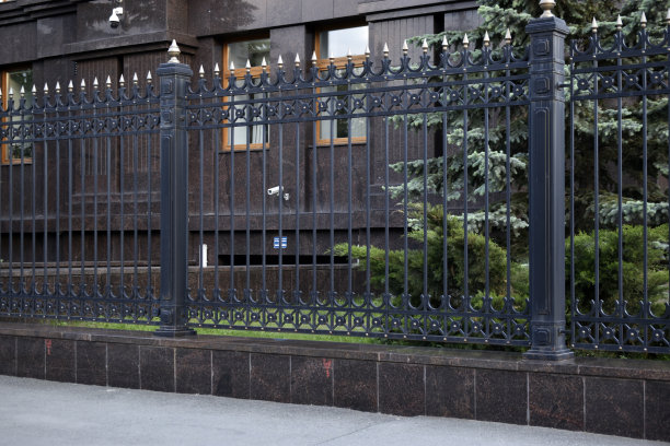 一个黑色的铁栅栏和一个红色的栅栏，下午有一所房子。图片下载