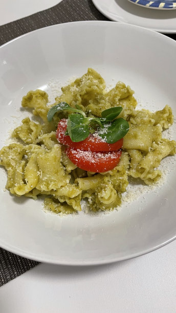 白盘子里的香蒜酱意大利面配樱苣和圣女果图片下载