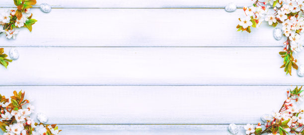 复活节白色背景。春天的花朵镶边，白色的快乐彩蛋在春天的木头背景上。复活节卡片。平的。图片下载