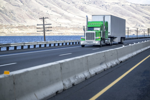 低驾驶室轮廓经典的绿色大卡车运输满载干货车半挂车行驶在哥伦比亚河的道路上图片下载