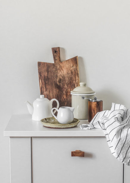 温馨的斯堪的纳维亚风格厨房。简单的陶瓷餐具，白色餐桌上的木制砧板图片下载