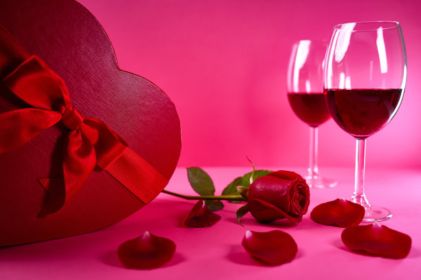 情人节:酒杯，红玫瑰，心形盒子，粉色背景图片下载