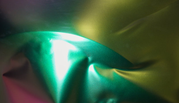 在工作过程中用变色龙色乙烯薄膜包裹汽车的专家。汽车包装专家用乙烯薄膜覆盖汽车。图片下载