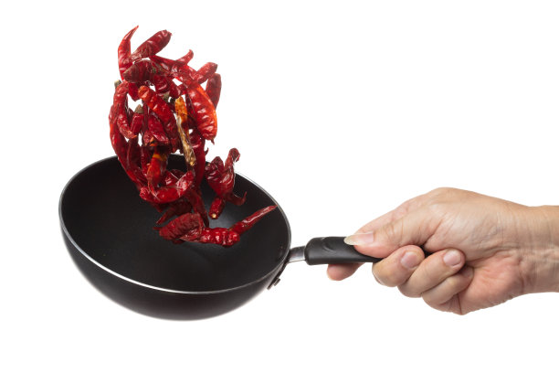 干红辣椒炸了扔在锅里，干红辣椒浮爆炸，抽象云飞。干红辣椒洒在空气中。白色背景隔离高速快门，定格图片下载