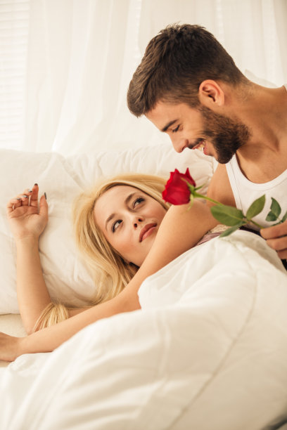年轻男子醒来后，在床上送她一朵玫瑰花，给女友一个惊喜图片下载