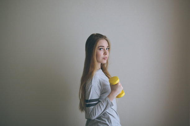 苗条的金发女孩，手里拿着哑铃，锻炼图片下载