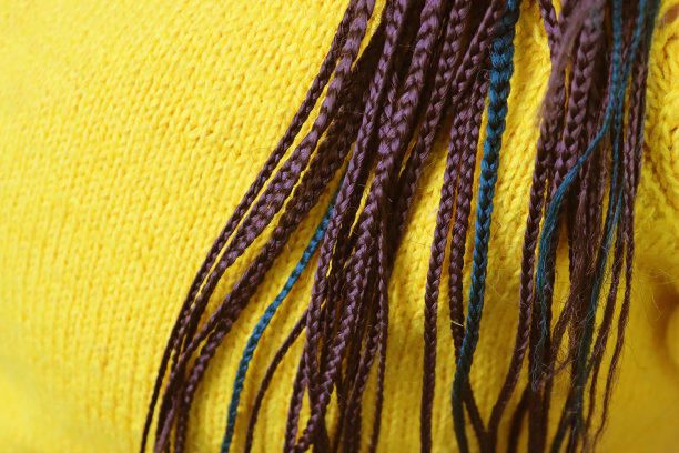 穿黄毛衣梳脏辫的女孩。近距离视图图片下载