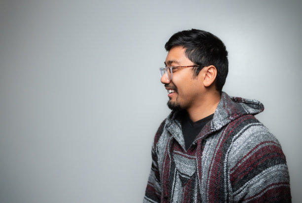 工作室肖像-墨西哥巴哈帽衫套头毛衣-软灰色背景-积极的情绪-侧面图片下载