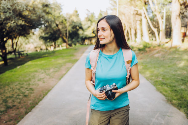 年轻漂亮的女孩，拿着老式相机在公园外面图片下载