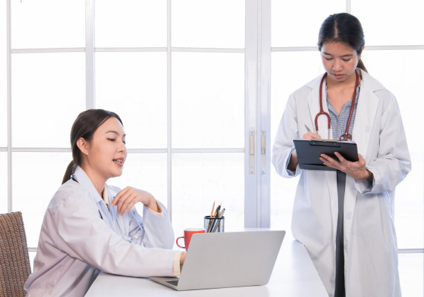 两位亚洲女医生讨论开会办公室医疗诊所用笔记本电脑一起分析数据，漂亮的护士一起交流和检查病人的历史。图片下载