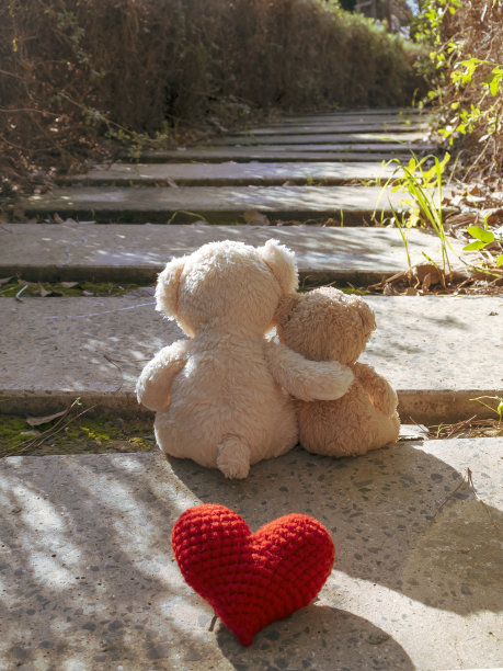 人行道上有两只泰迪熊和红心图片下载