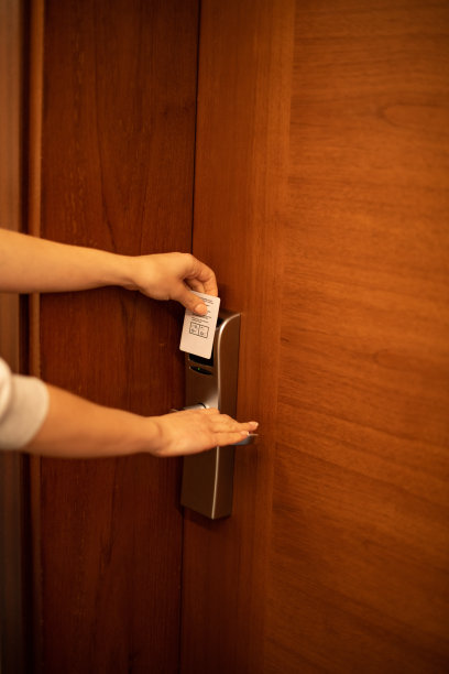 一名女子用钥匙卡打开酒店房门图片下载