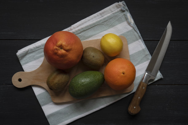 在砧板上用刀把水果和蔬菜切一半作为素食背景图片下载