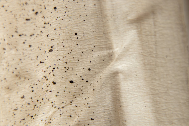 棕色的纸上有油漆斑点作为背景，颜料溅在纸上作为背景图片下载