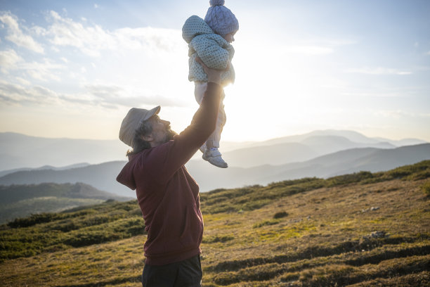 日落时分，爸爸带着孩子在大自然中徒步旅行。图片下载