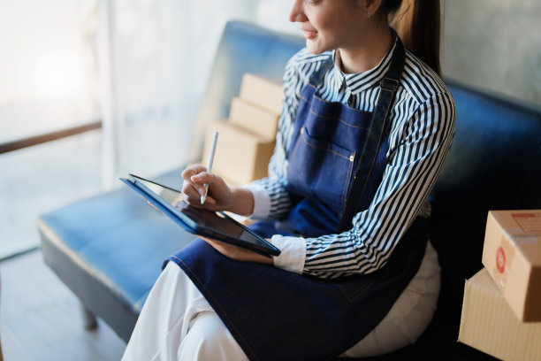 开始创业的独立亚洲女性在线卖家与客户通电话，并包装产品交付给客户。和中小企业交付概念图片下载