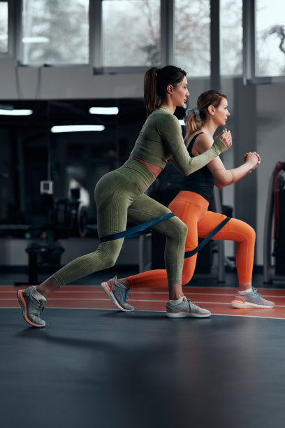 运动妇女在健身房锻炼弹性阻力橡皮筋。图片下载