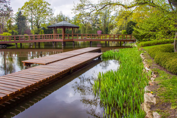 四月下旬，弗罗茨瓦夫的日本花园中令人惊叹的风景，穿过池塘的木制小径图片下载