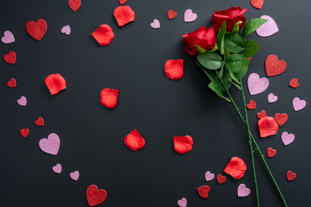 美丽的情人节背景与红色的心和红玫瑰的黑色横幅背景。图片下载