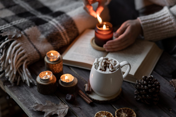 温馨的秋冬搭配香薰蜡烛、羊毛衫、书籍。香薰，温馨放松的家居氛围。木质背景特写。图片下载