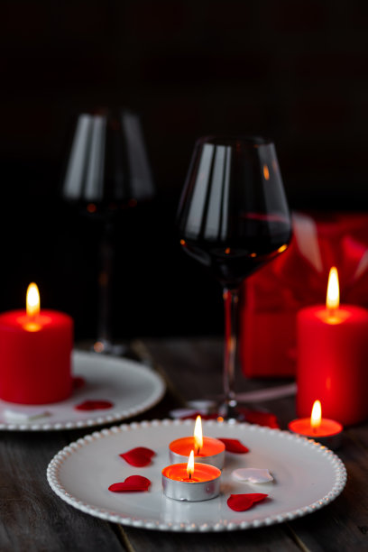 情人节庆祝活动。红色燃烧的蜡烛，爱心，礼品盒，明信片在黑暗的木制背景。节日快乐。餐桌装饰喜庆，气氛浪漫图片下载