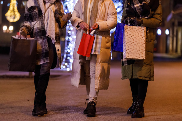一群朋友背着购物袋走在城市的街道上图片下载