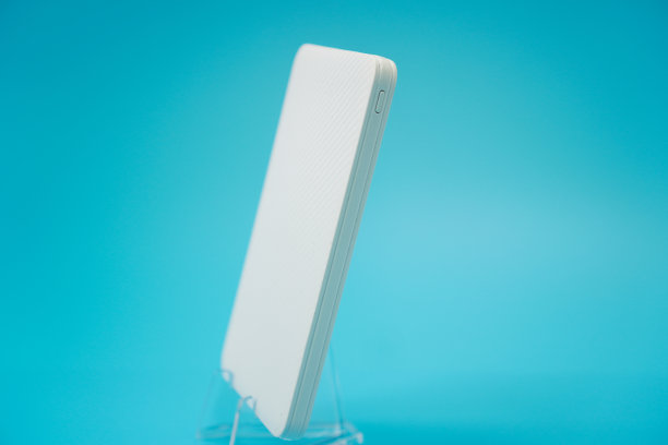 图像显示蓝色背景上的白色超薄备用电池，特写，隔离。图片下载