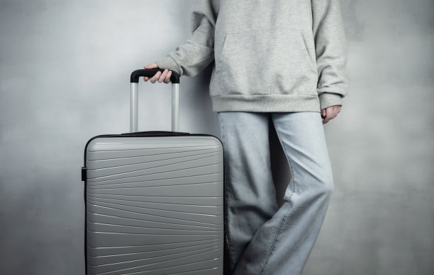 一个提着灰色行李箱的女孩正要去休息。旅行的概念。图片下载