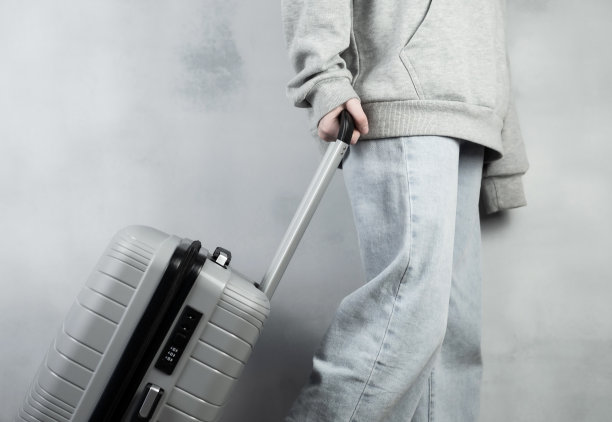 一个提着灰色行李箱的女孩正要去休息。旅行的概念。图片下载