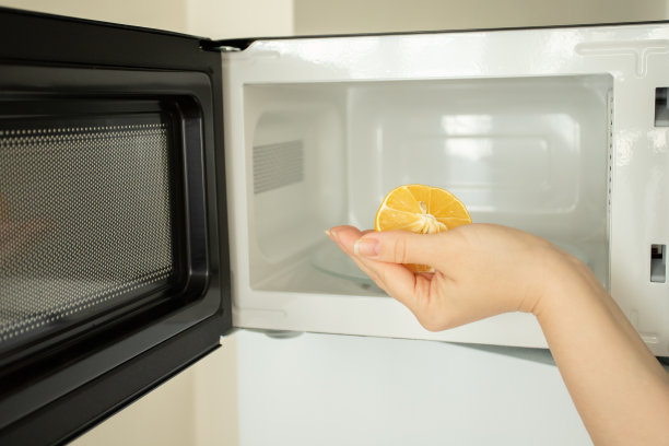 柠檬微波炉清洁剂在女性手中图片下载