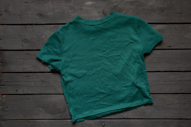 绿色针织女式毛衣躺在黑色木板上，温暖的女式服装图片下载