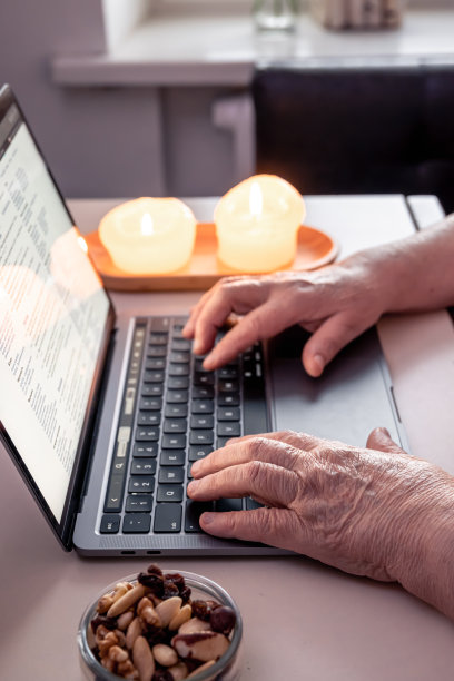 退休妇女使用笔记本电脑，双手靠近。图片下载