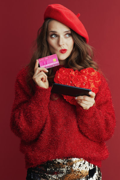 沉思的女人在红色毛衣和贝雷帽浏览网上商店图片下载